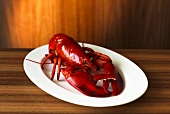 A whole cooked lobster on an elegant wooden surface