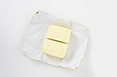 A pat of butter, halved, on paper