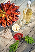 Cook crayfish, crisp breads, butter and wine on a wooden table