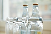 Umgedrehte Wassergläser vor Wasserflaschen