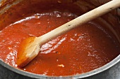 Pot of Simple Tomato Sauce; Wooden Spoon