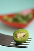 Half a mini kiwi (actinidia arguta) on a fork