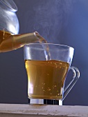 Hot tea being poured into a glass