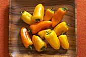Yellow and orange mini peppers in a wooden crate