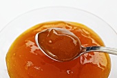 Apricot jam in a bowl and on a spoon