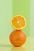 An orange half on top of a whole orange