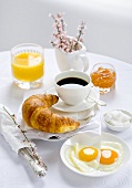 Breakfast with coffee, croissant, fried egg, jam and orange juice