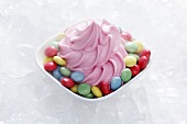 Strawberry yogurt ice cream with colourful chocolate beans