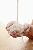 Raw sugar flowing into hands