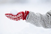 Eine Person hält einen Schneeball