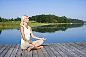Blonde Frau beim meditieren im Lotussitz
