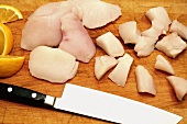 Whole and Cut Fresh Halibut Cheeks; Cutting Board and Knife