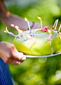A woman carrying a birthday cake with candles