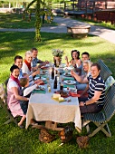 Menschen beim Essen im Garten (Mittsommerfest, Schweden)