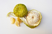Ugli Fruit; Whole, Peeled and Segments; From Above; White Background
