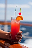 A woman holding a fruit cocktail