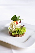 A canape with cream cheese and lettuce