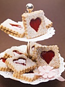 Jam biscuits with icing sugar on a cake stand