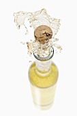 White wine spraying out of a bottle