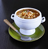 Bowl of Minestrone Soup on a Green Plate with Spoon
