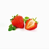 A whole strawberry and half a strawberry