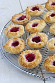 Coconut macaroons with raspberry jam on a wire rack
