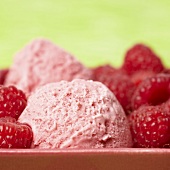 Two scoops of raspberry ice cream with fresh raspberries (close-up)