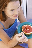 Woman eating grapefruit