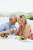 An older couple having lunch on a boating holiday