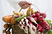 Woman holding basket of vegetables