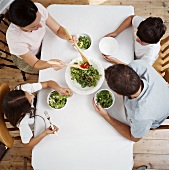 A family eating salad at a table