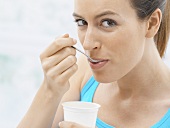 Young woman eating yoghurt