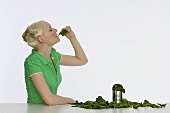 Young woman eating spinach