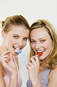 Two young women with lollipops