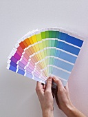 A woman holding colour charts