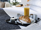 A breakfast tray on a hotel bed