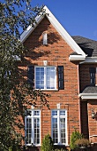 Stattliche Backsteinfassade eines Hauses mit spitzem Giebel und hohen Sprossenfenstern