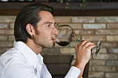 A man tasting a glass of red wine