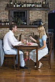 A couple sitting at a table in a wine bar