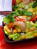 Avocado puree, shrimps & chick-peas on salad leaves