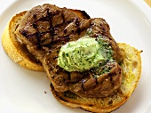 Barbecued pork neck with herb butter on white bread