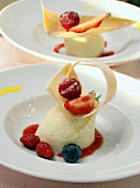 Yoghurt mousse with fruit sauce, garnished with berries