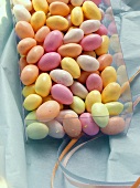 Pastel-coloured sugar eggs (jelly beans) in plastic box