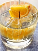 Cocktail with orange and ice cubes