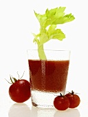 Tomato juice in glass with celery; cherry tomatoes