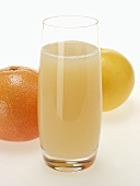 Grapefruit juice in glass and various grapefruits