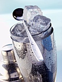 Ice cubes in cocktail shaker with bar spoon