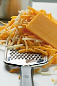 Mozzarella and Cheddar, partly grated, with cheese grater