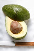 Avocado, halbiert, mit Messer