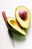 Avocado, halved, with knife